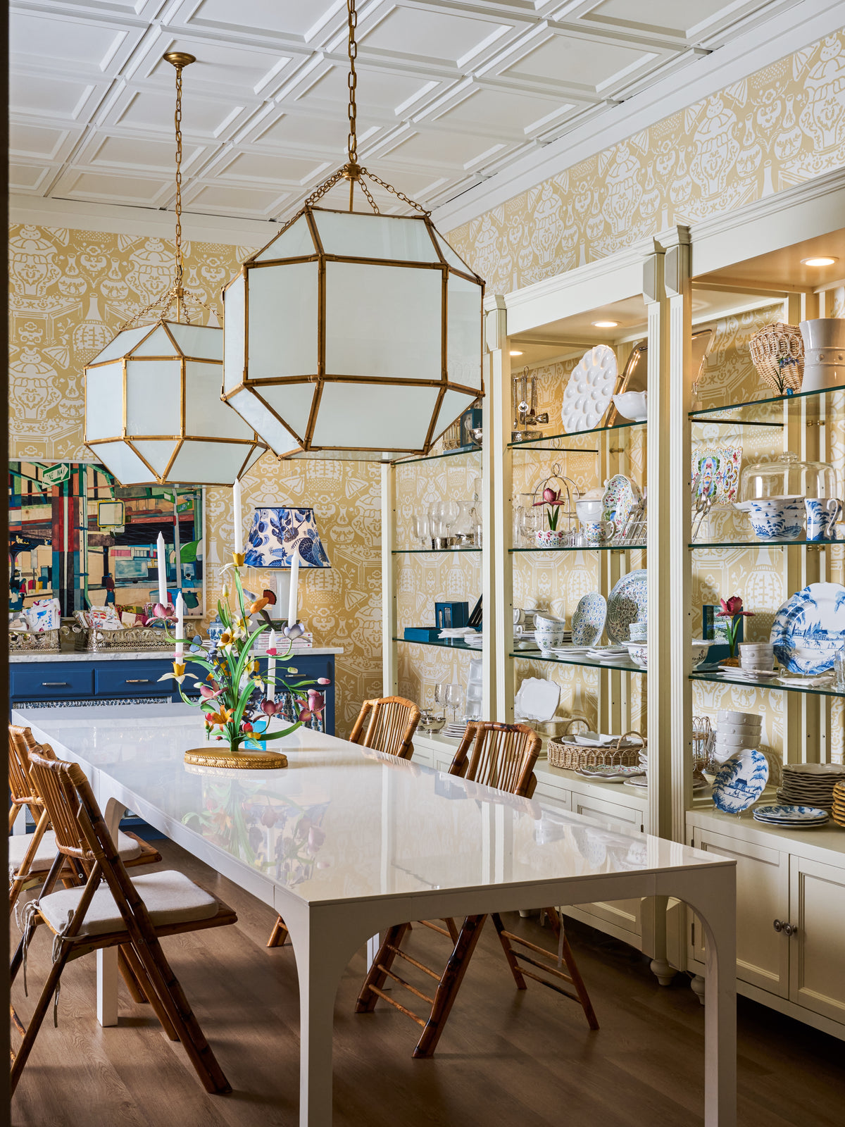 Geometric brass pendant lights above a dining table in the Modern Grace & Co. showroom.