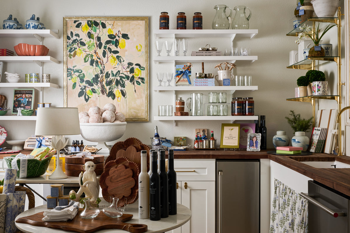 Gift and home accessory displays beside the shop counter and floral artwork.