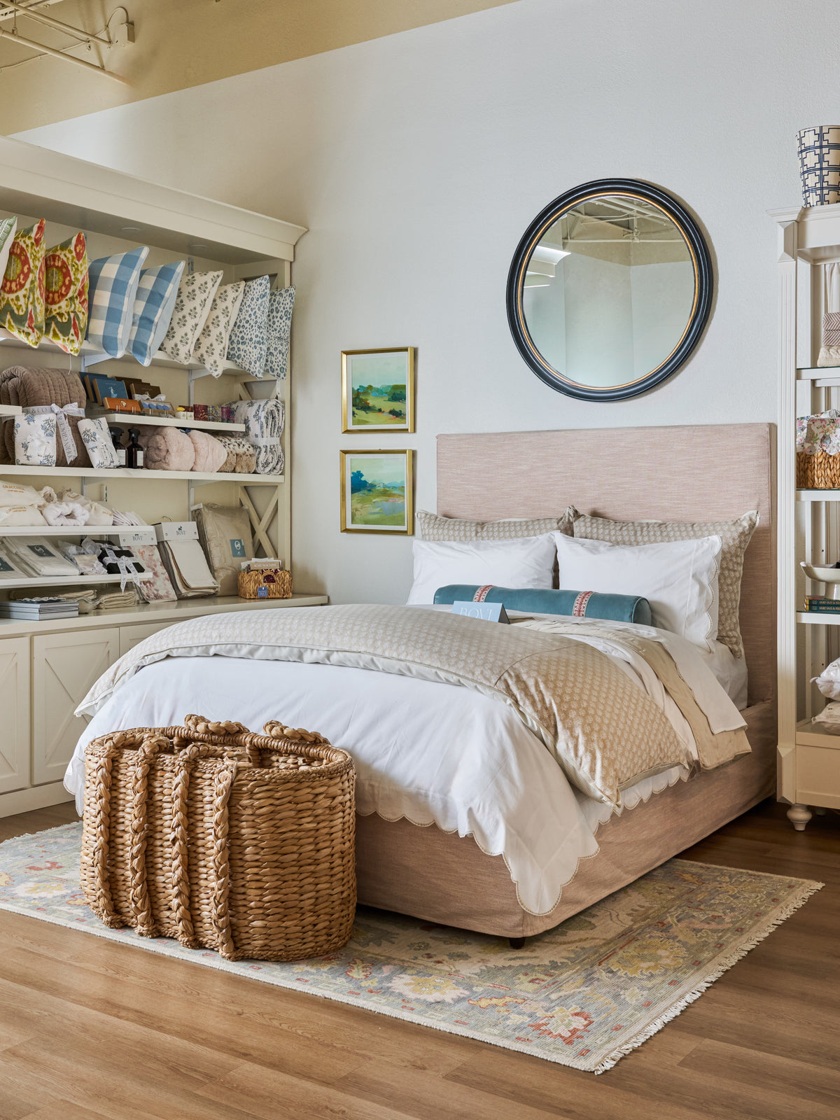 Layered neutral bedding and accent pillows on an upholstered bed at Modern Grace & Co.