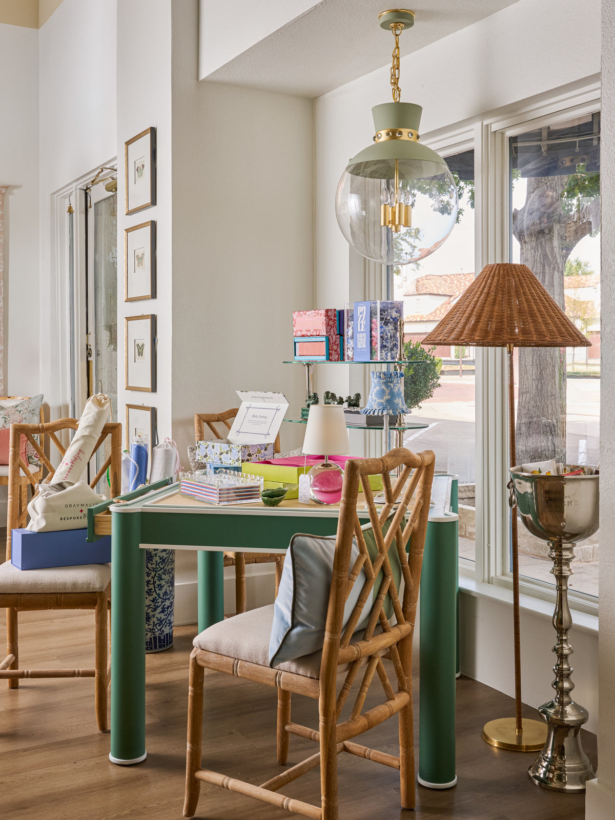 Green game table and woven chairs in a styled Modern Grace & Co. showroom display.